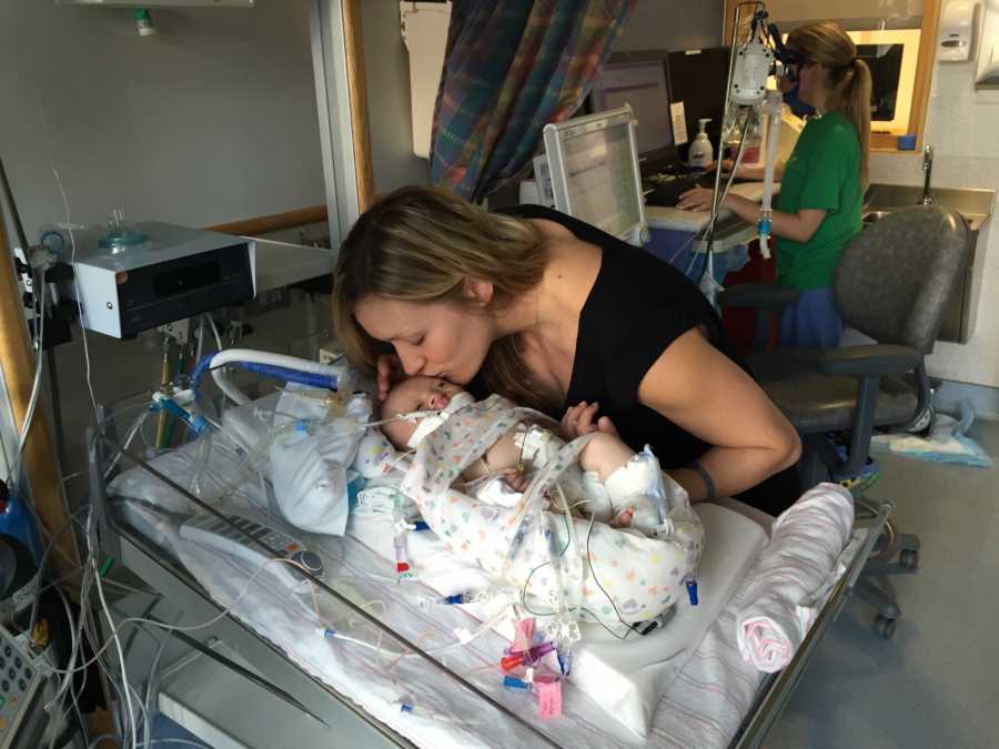 Mother leans over to kiss newborn who lays in NICU and will soon die