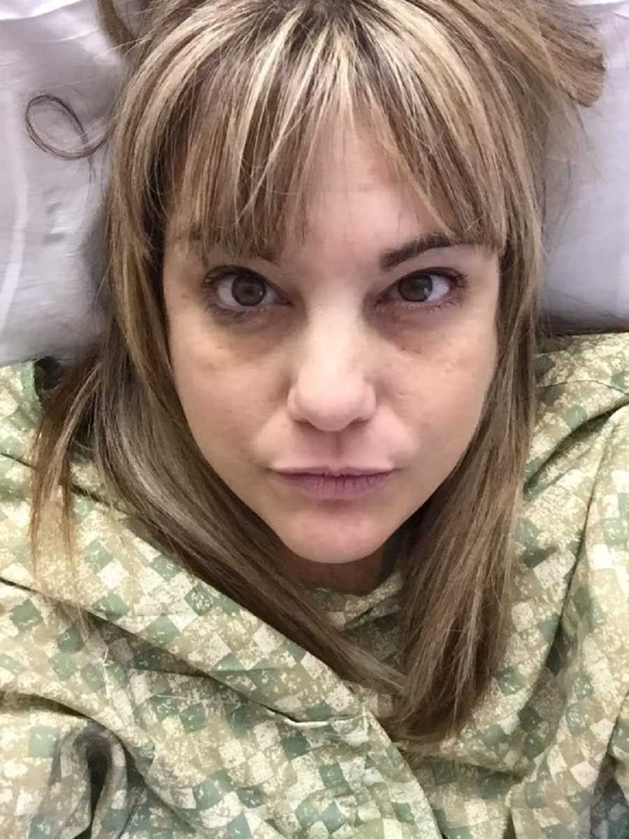 Widow takes selfie as she lays in hospital bed with hospital gown on