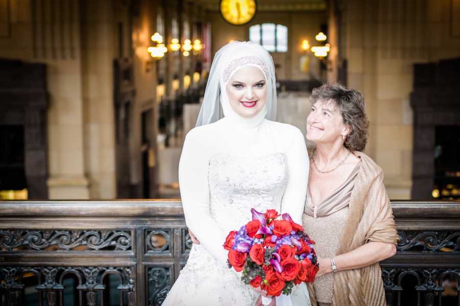 Bride who converted to Islam stands smiling beside her mother 