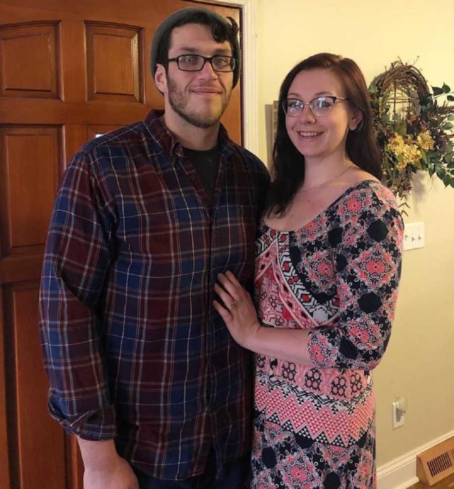 Woman who finally loves herself stands smiling in home beside her husband