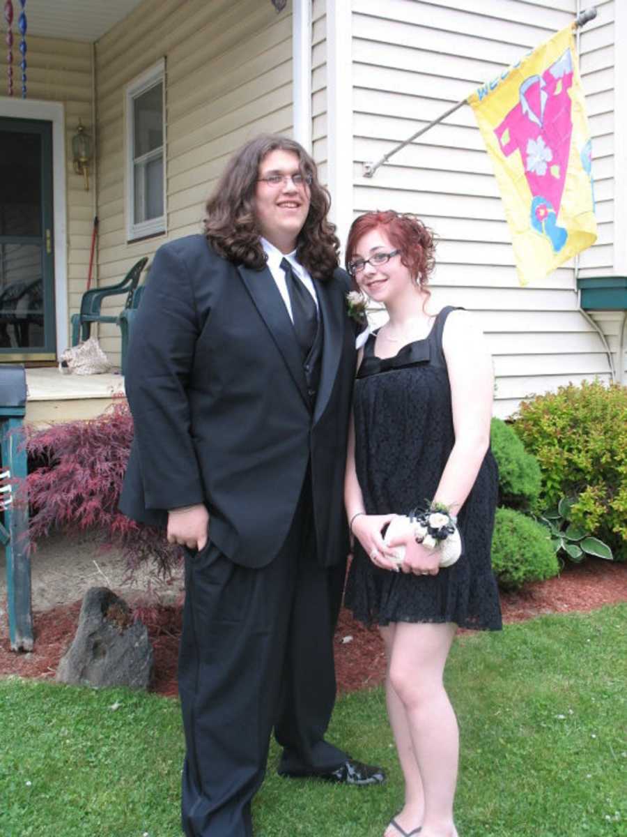 High school teens standing outside of home dressed for school dance