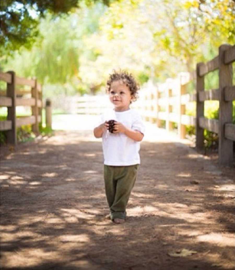 Little boy who had open heart surgery smiles as he walks along dirt path