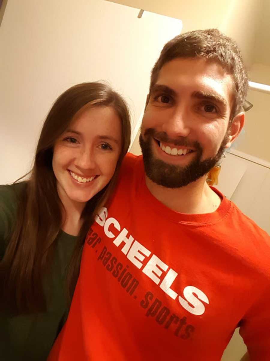 Husband and wife smile as they take selfie in bathroom