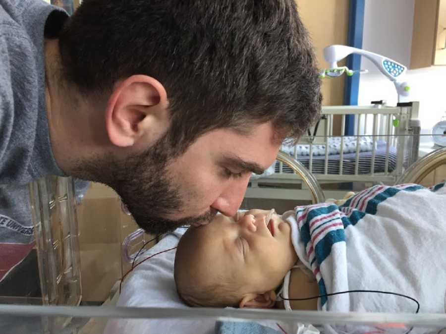 Father kisses forehead of newborn with NEC
