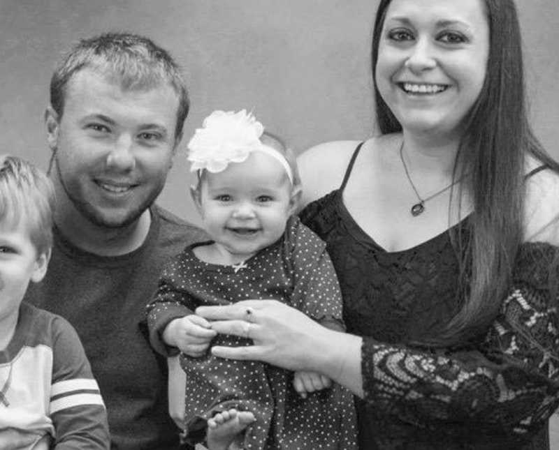 Husband and wife smiles with their two young children