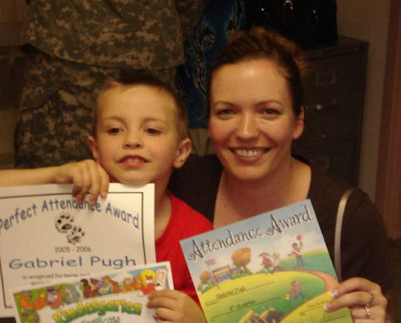 Mother smiles with son who has ADHD who holds perfect attendance award