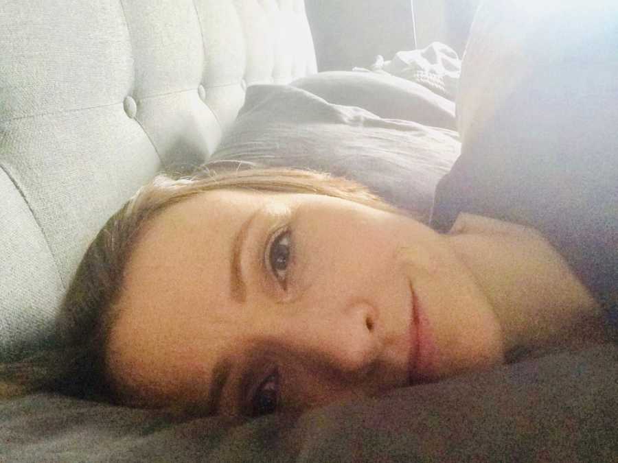 Woman who has cancer lays in bed taking selfie