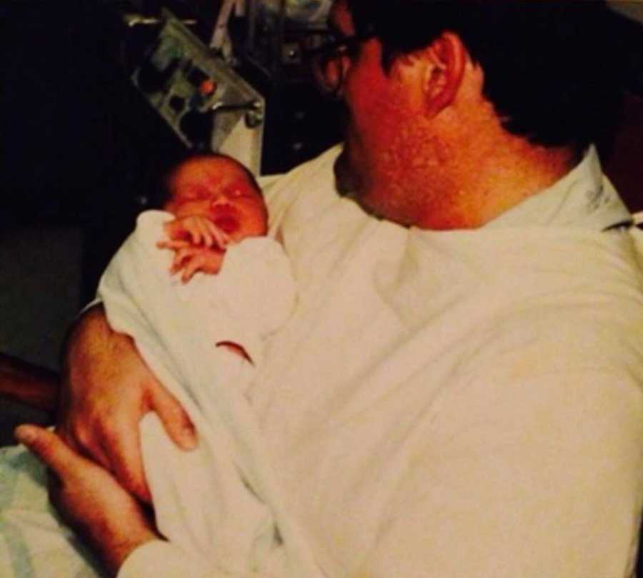 Father sits with newborn in his arms who was switched at birth