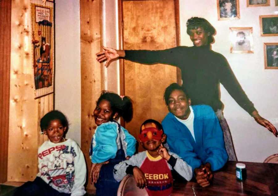 Young girl with vitiligo sits in home beside three siblings and mother