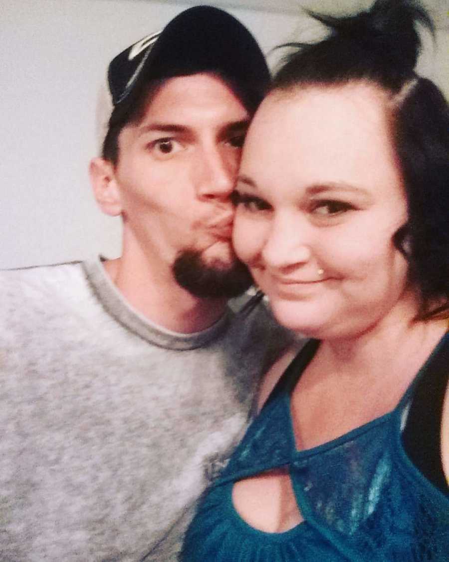 Woman with diabetes smiles as her boyfriend kisses her on the cheek