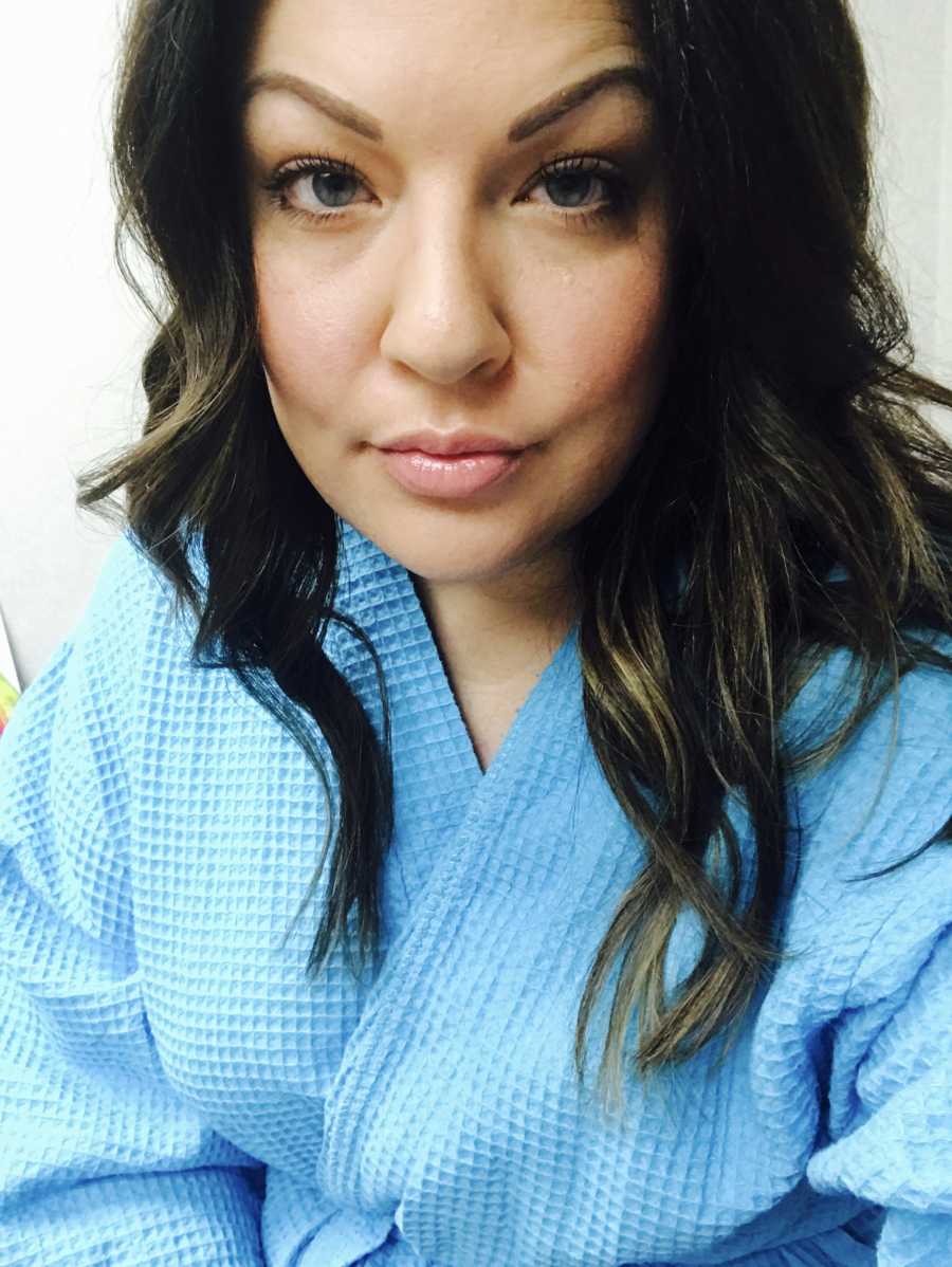Woman who is depressed about not being pregnant takes selfie in blue robe