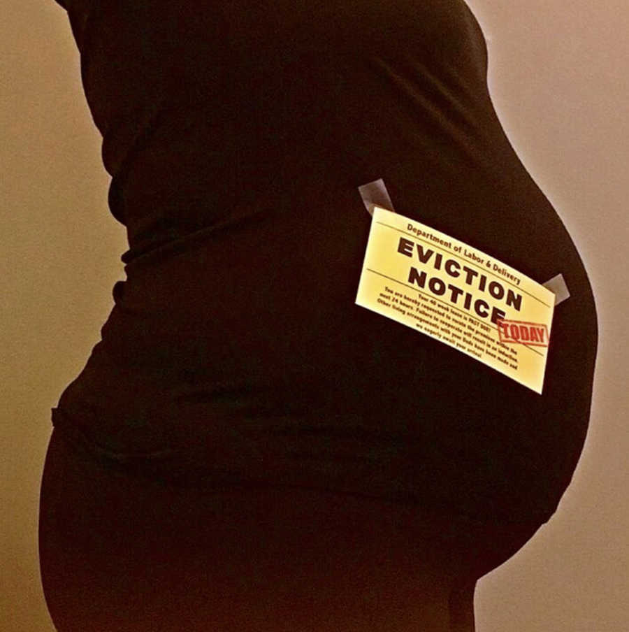 Surrogate's pregnant stomach with eviction notice note taped to her