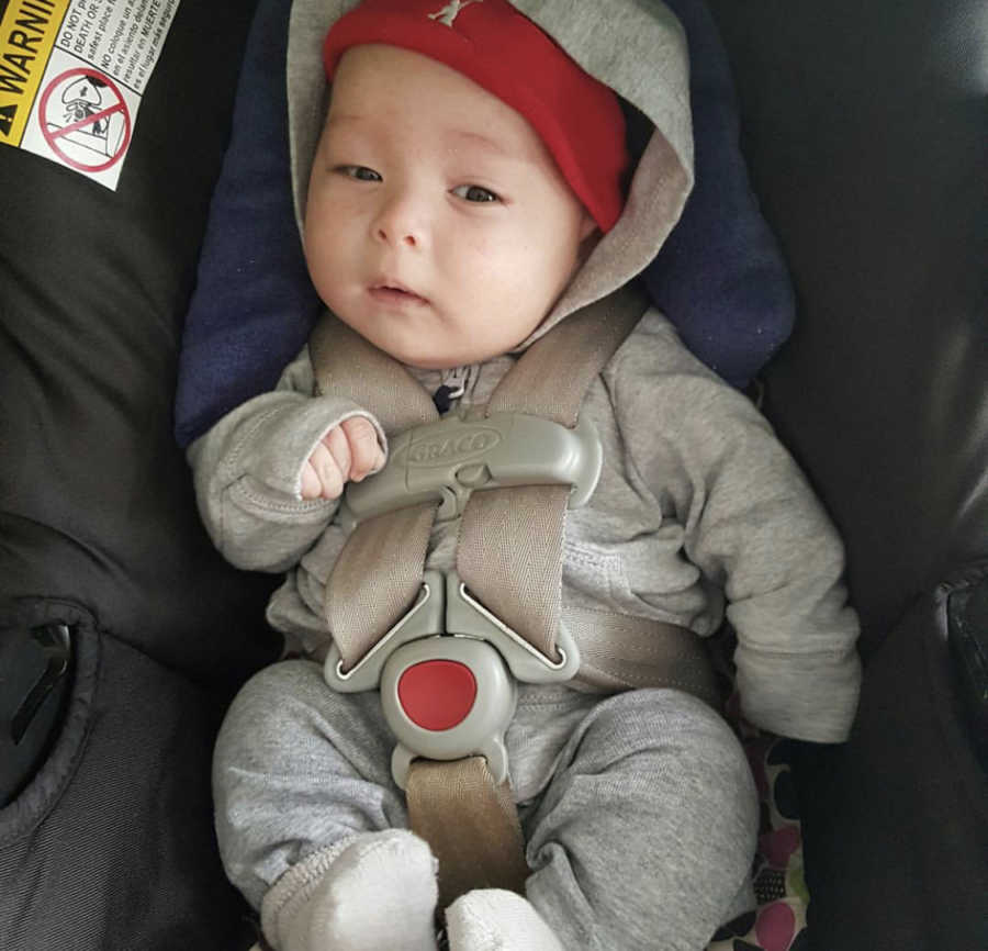 Baby boy sits in carseat ready to go home after being in NICU for a few weeks