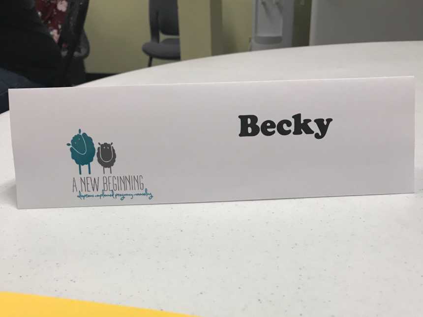 Name tag on table for woman who is at class learning about adoption