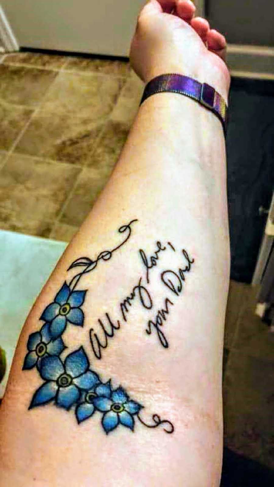 Woman's forearm that has tattoo of her deceased father's writing 