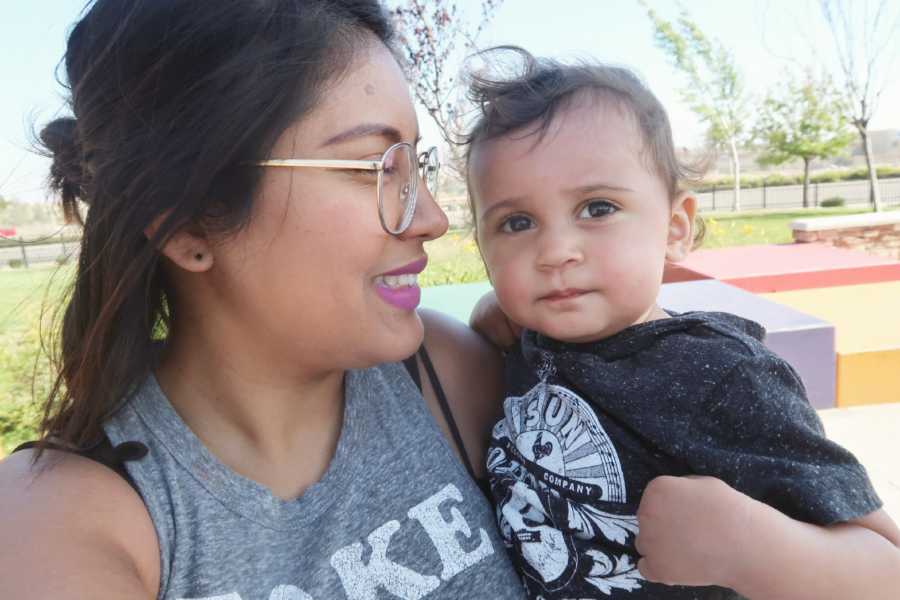 Woman smiles at her son while she holds him in selfie