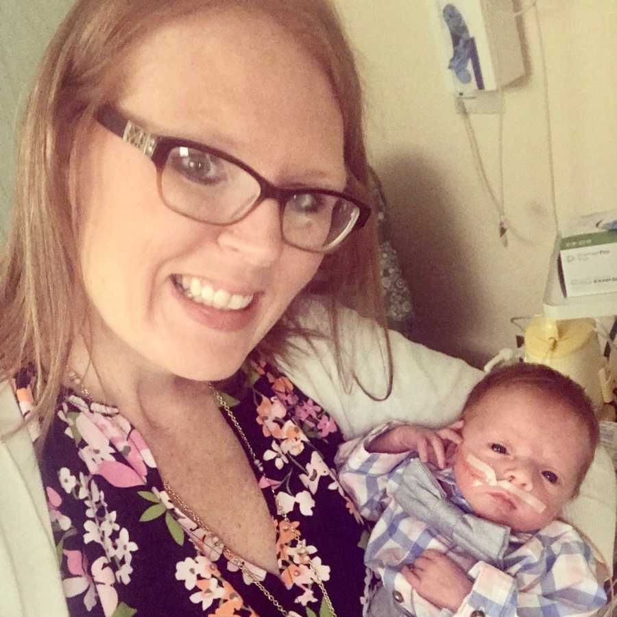 Mother smiles in selfie as she holds preemie baby in her arm