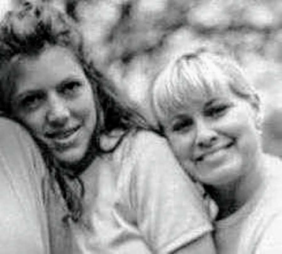 Woman who lost contact with her sister stands outside leaning her head on her shoulder when they were younger