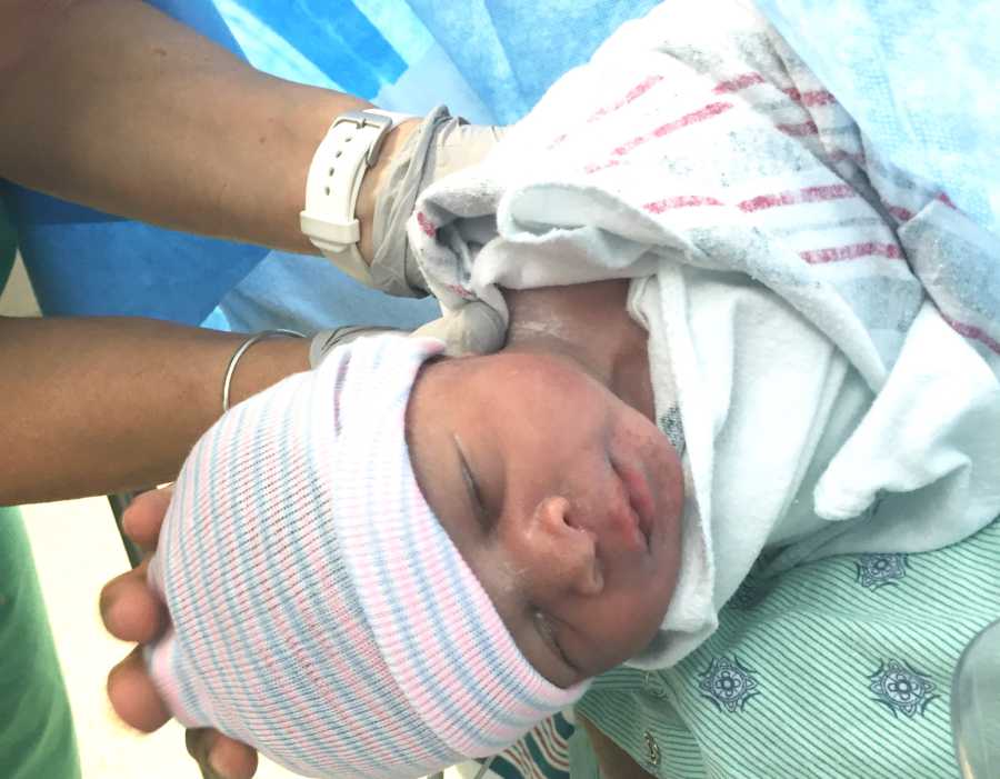 Newborn lays asleep swaddled in hospital blanket whose mother was diagnosed with sepsis