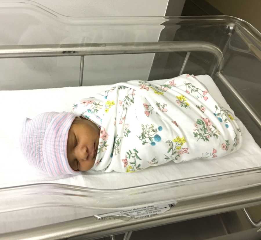 Newborn lays asleep swaddled in blanket in hospital while her mother may not make it
