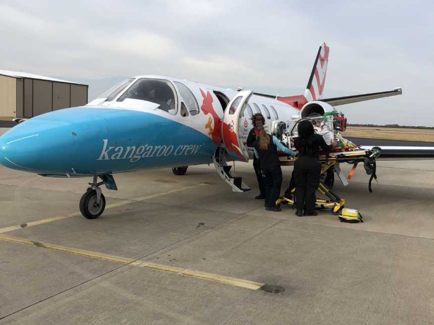 Baby girl with down syndrome lays on stretcher as she is loaded into plane for heart transplant