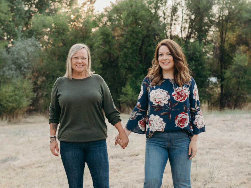 Woman stands outside holding her hand with her wife 