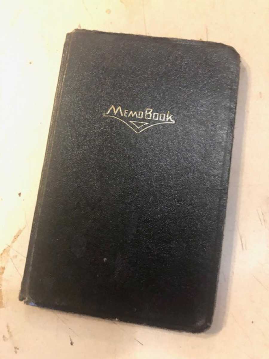 Black leather book labeled "memo book" sitting on counter