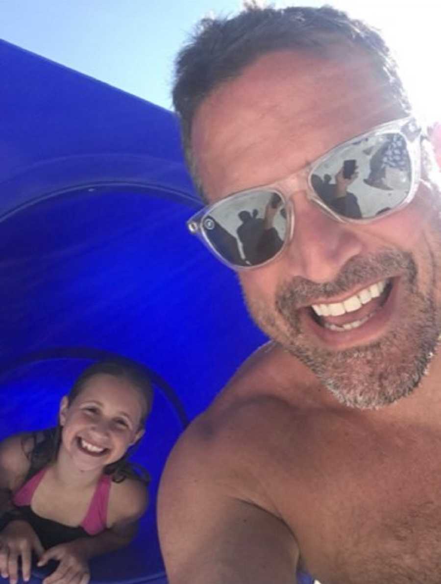 father takes a selfie with his daughter at the beach