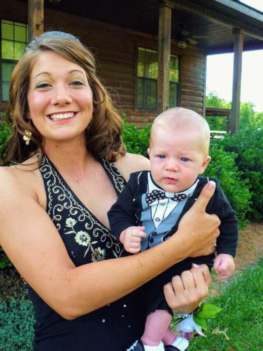 Mom in prom dress holding newborn baby in tuxedo shirt