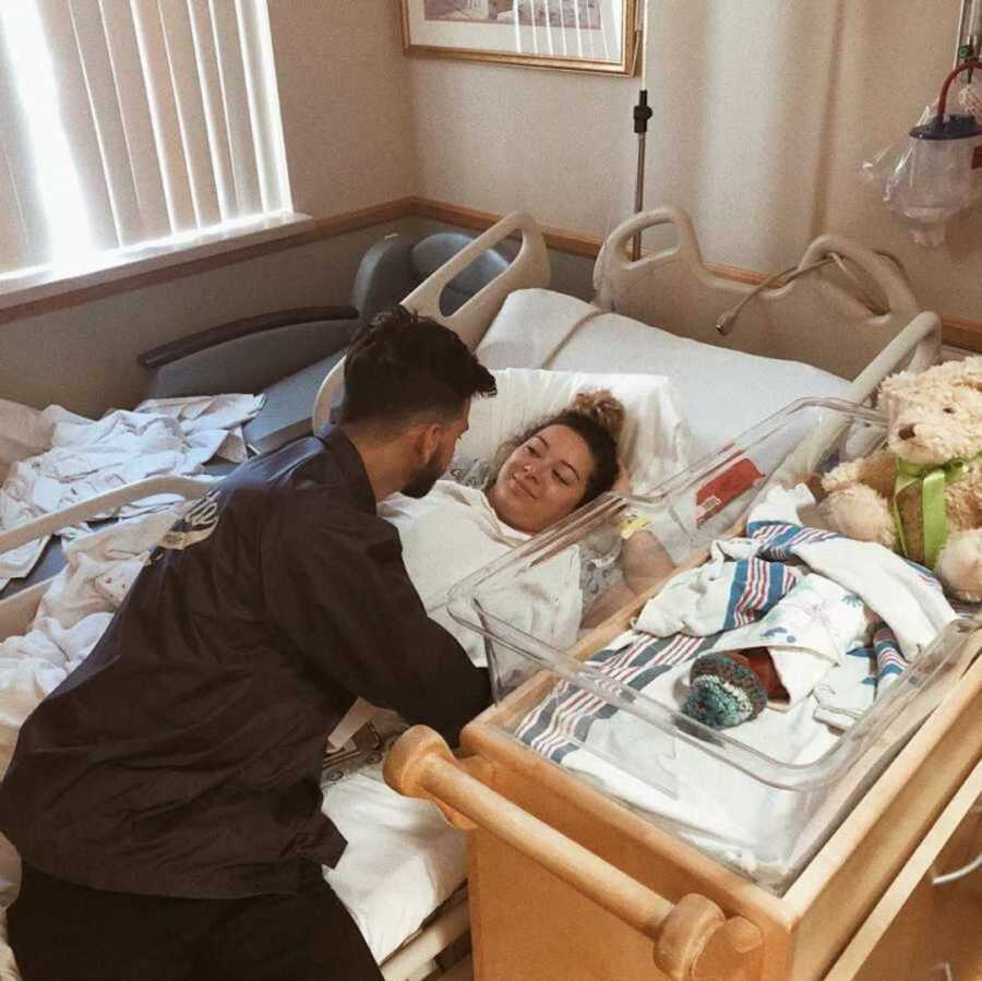 Boyfriend comforts postpartum girlfriend in hospital bed 