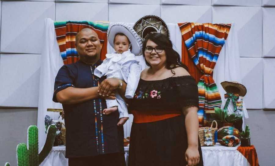 Mom and dad holding son dressed in traditional Mexican attire