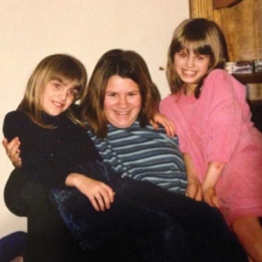 Mom embracing two daughters in hug