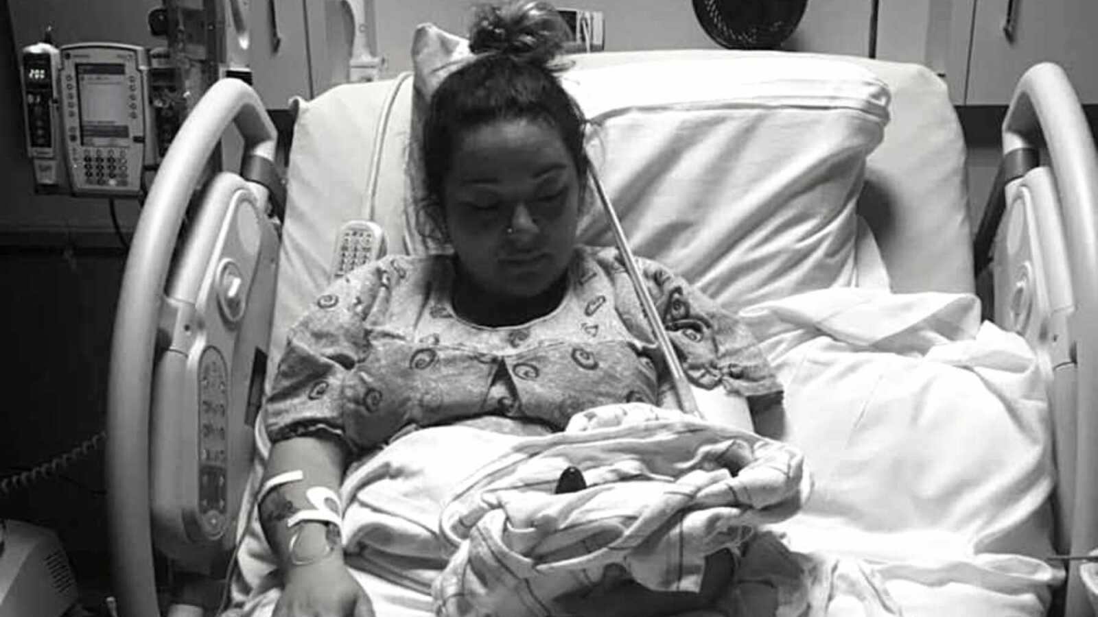 Grieving mom holds premature baby in hospital bed