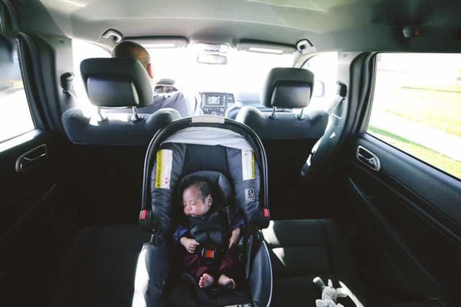 Newborn baby in black carseat