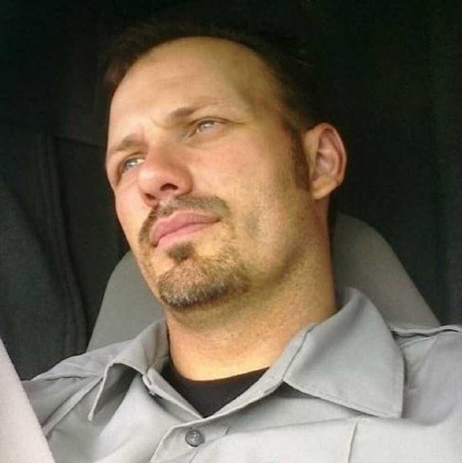 Paramedic in gray work shirt sitting in vehicle 