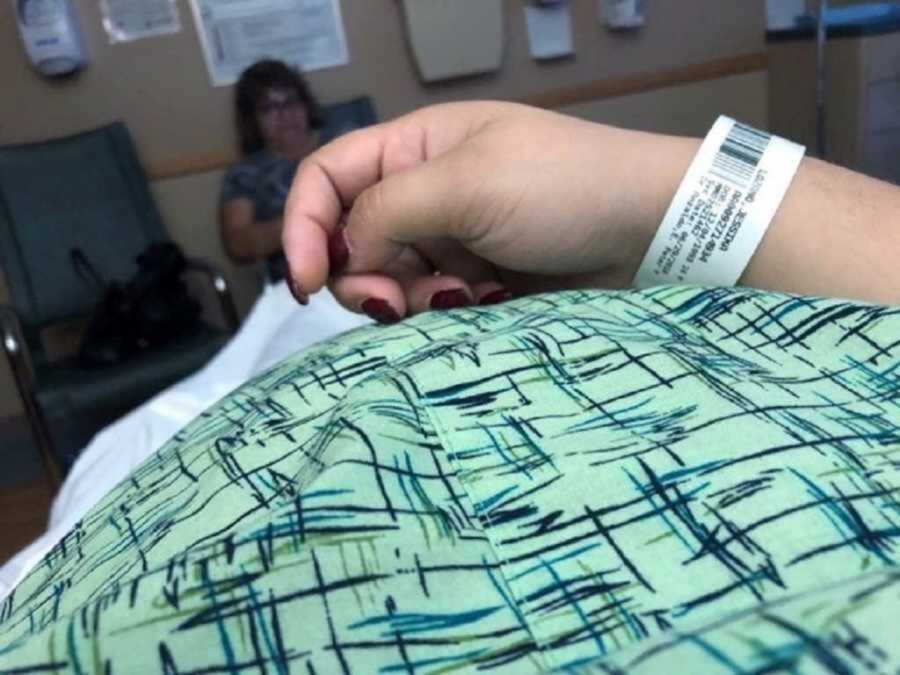Pregnant woman lying down in hospital gown
