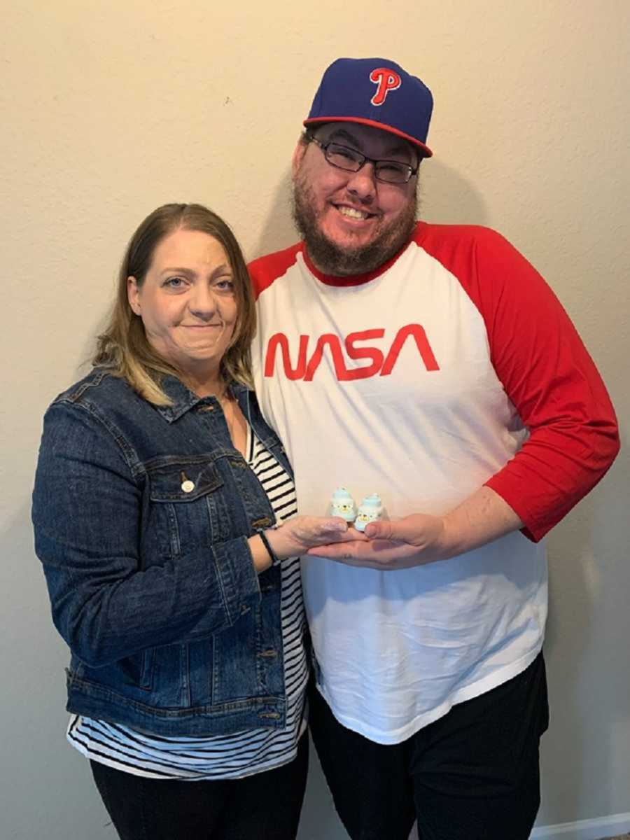 Husband and wife holding baby shoes