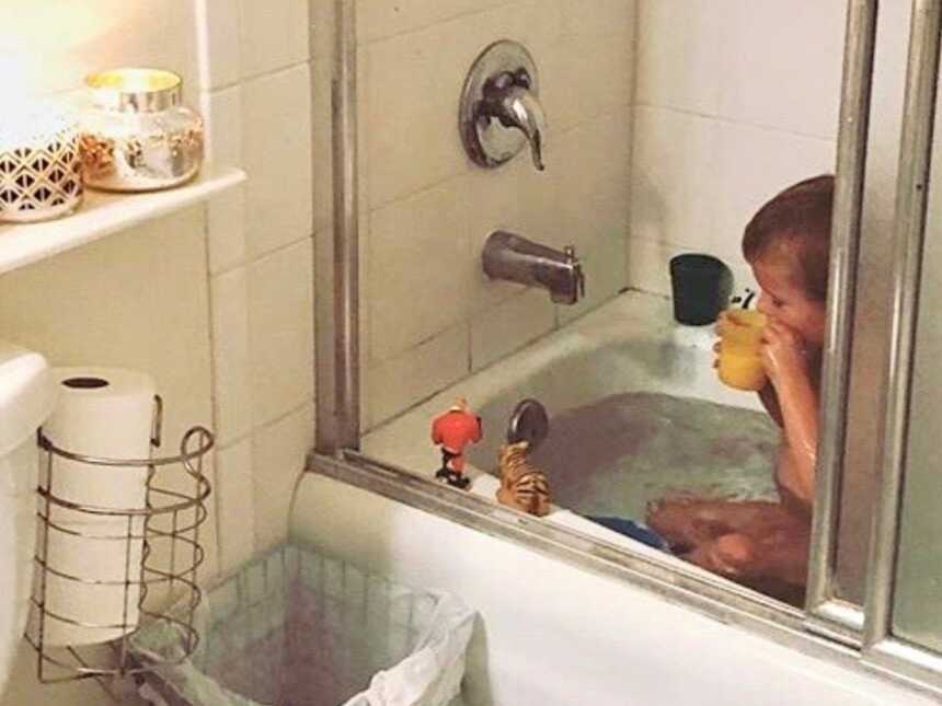child smells candle in bath