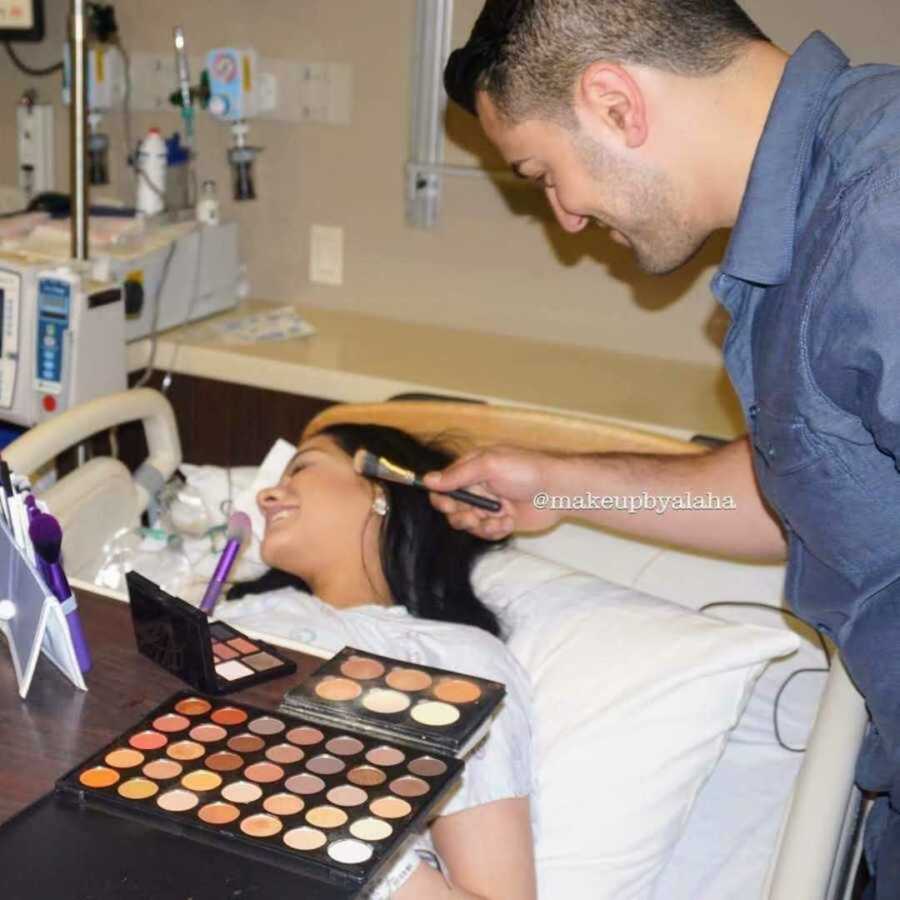 husband helps wife apply makeup during labor