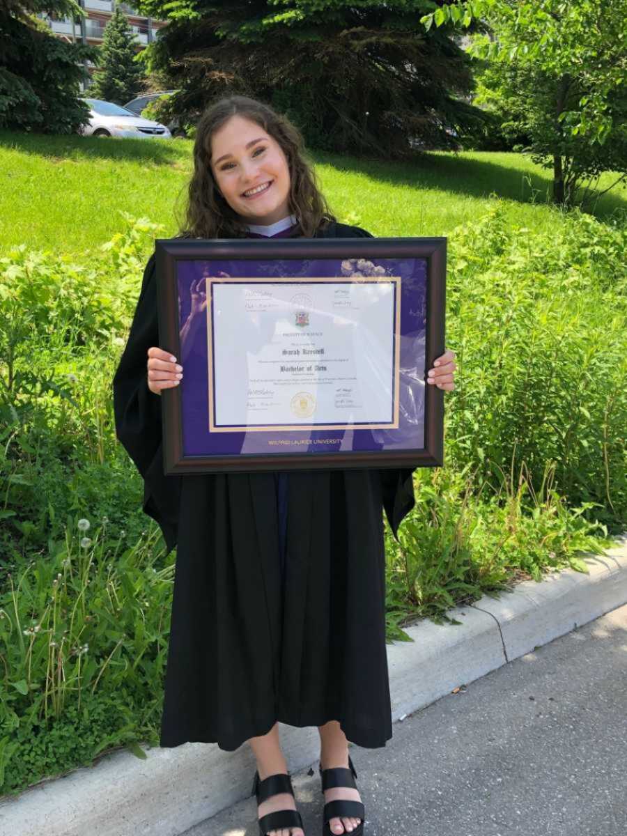 woman holding up her diploma