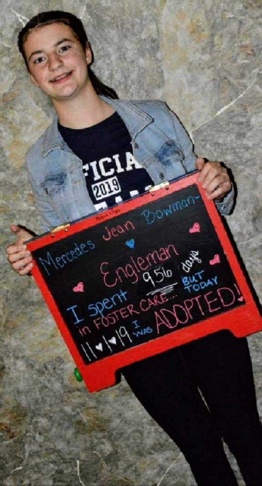 Adoptive daughter holds chalkboard