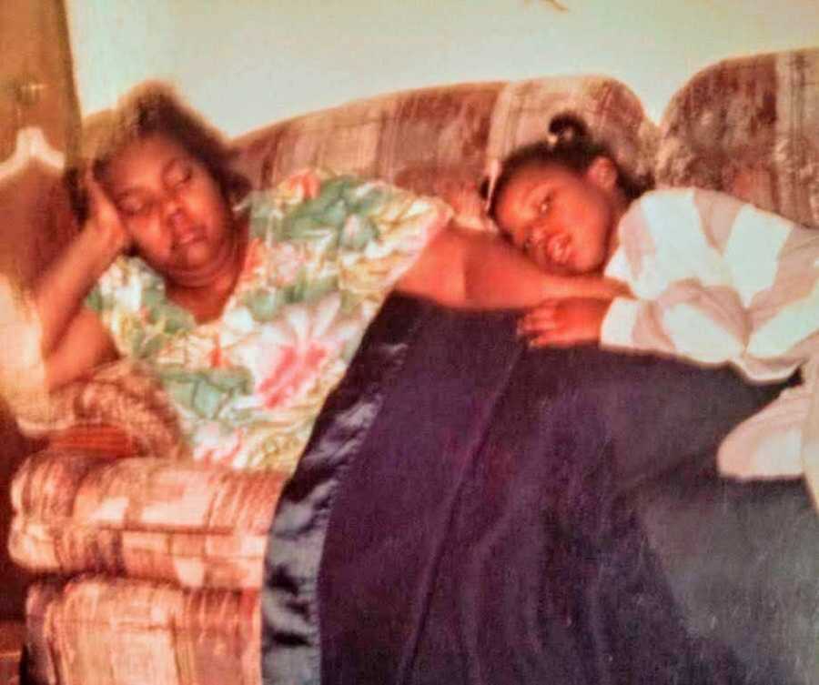 Little girl embracing mother on couch 