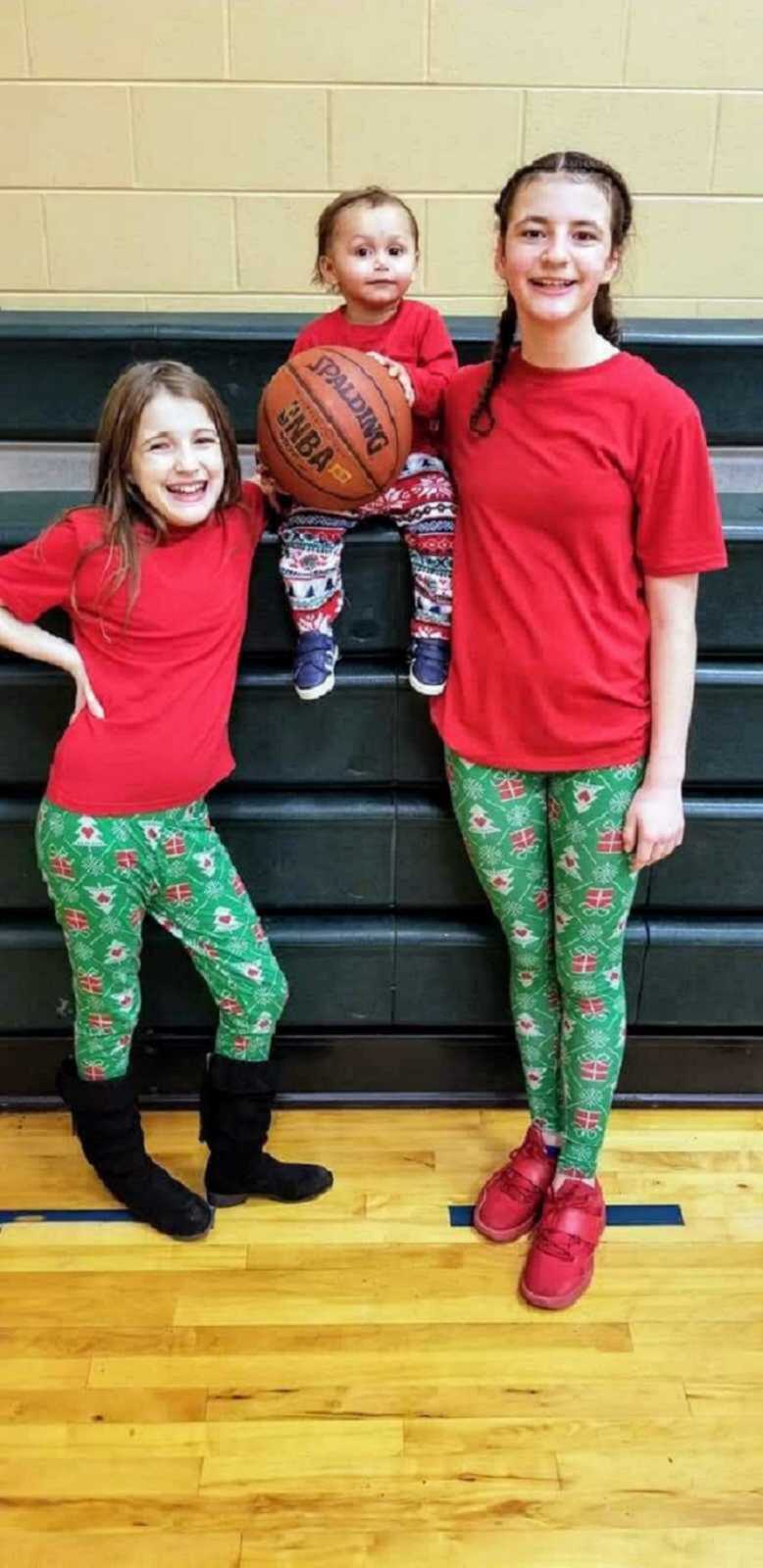 Three foster kids pose in Christmas pajamas