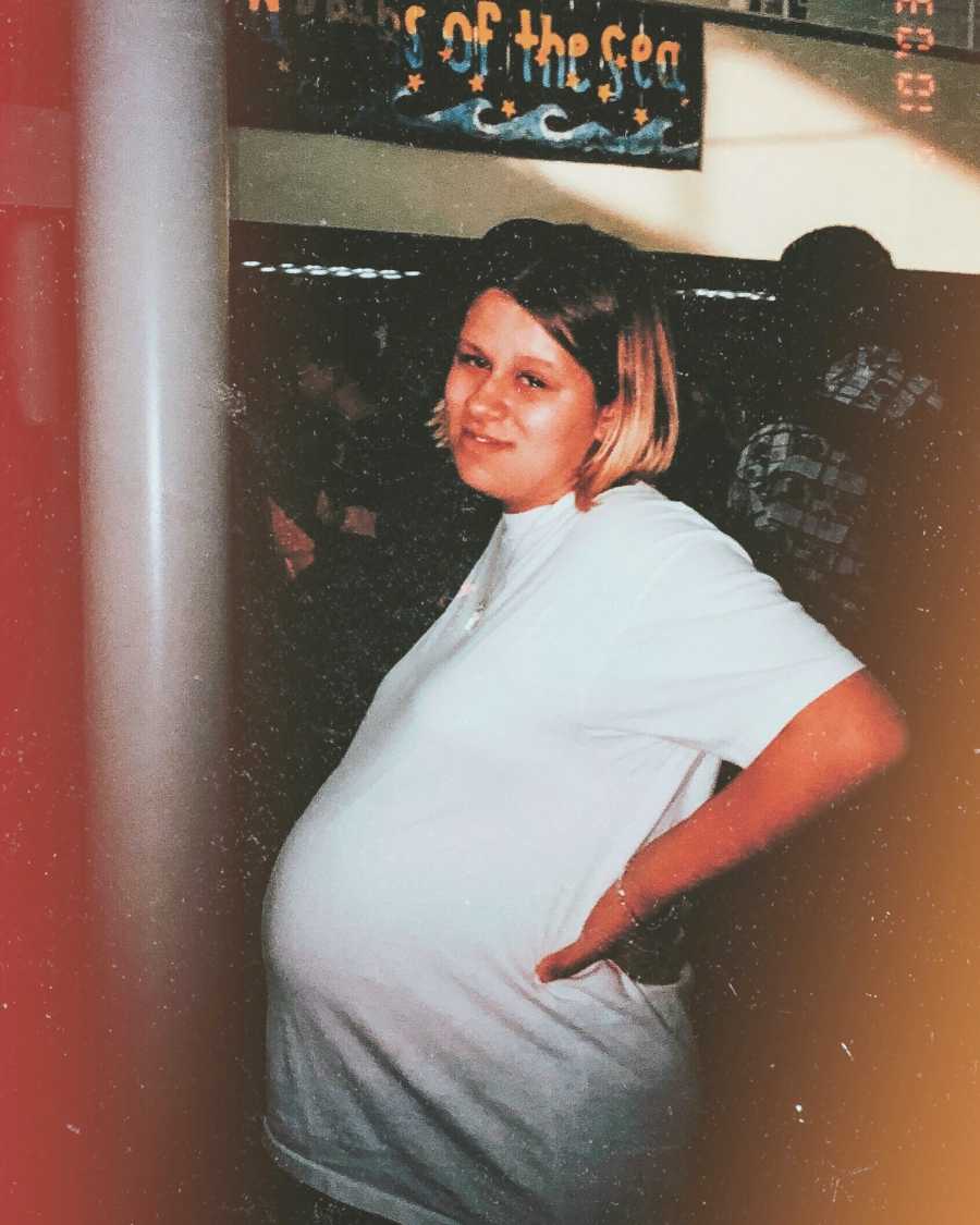 Young pregnant teenager takes photo showing her bump.