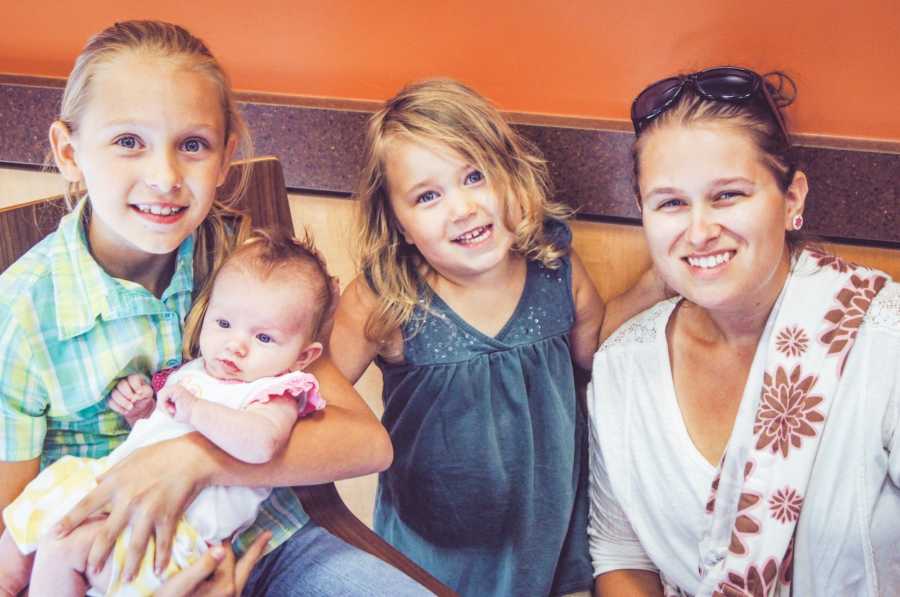 Birth mom reunites with birth daughter and takes picture including two sisters.