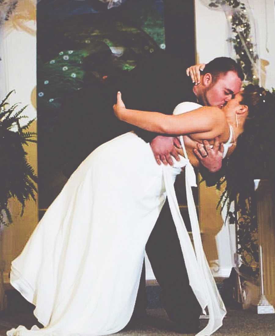 Husband dips wife and gives her a kiss on their wedding day