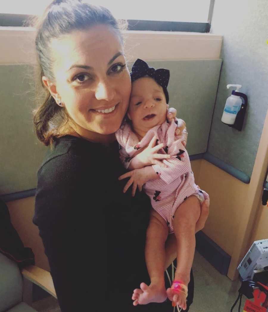 Eliza holding her daughter with Treacher Collins Syndrome