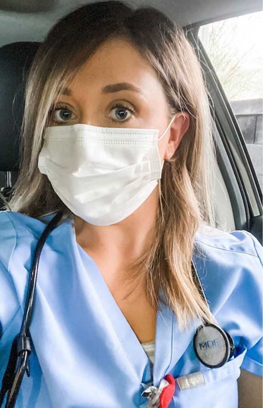 Nurse in scrubs wearing white mask