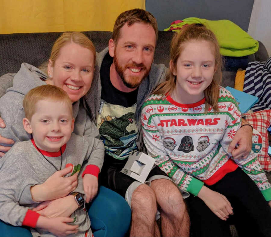 Biological parents smile with son and daughter