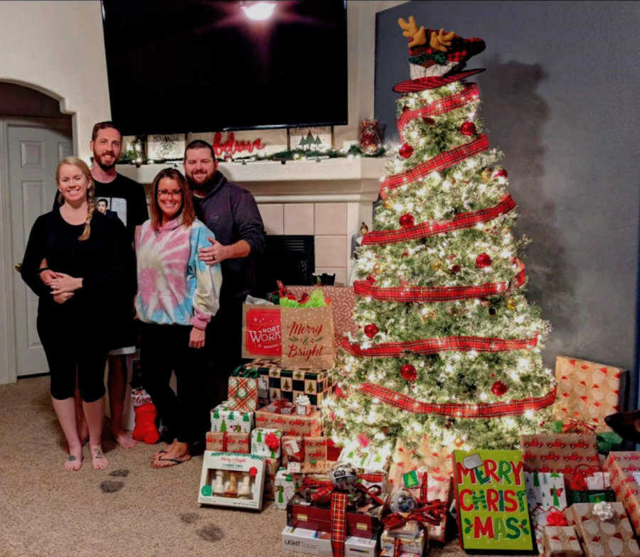 Blended family smiling and posing next to Christmas tree